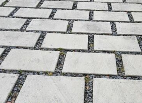 Concrete pavers sit upon stone to make up a driveway surface